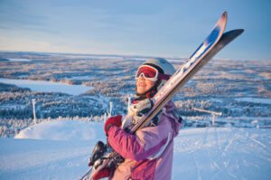 School girl carrying skis