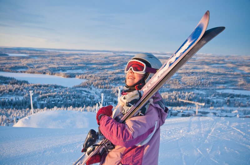 School girl carrying skis