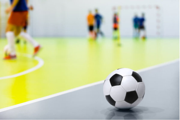 Children playing futsal indoors Children playing futsal indoors